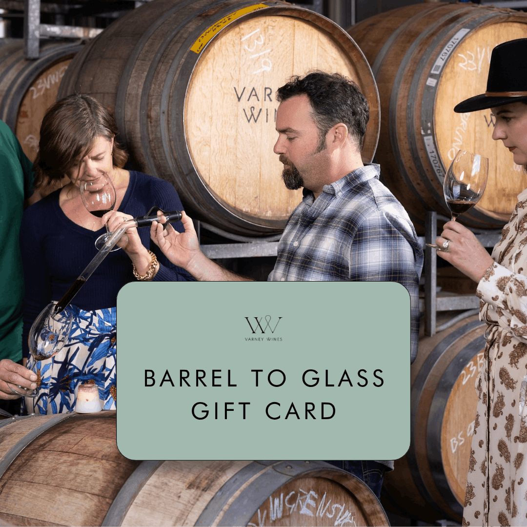 People tasting wine in front of barrels with a 'Barrel to Glass Gift Card' overlay.