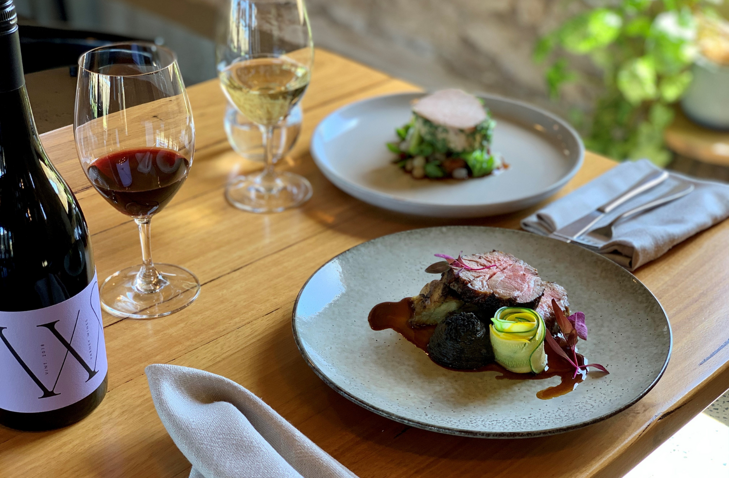 Varney Wines GSM on table set with a meat dish and chicken dish