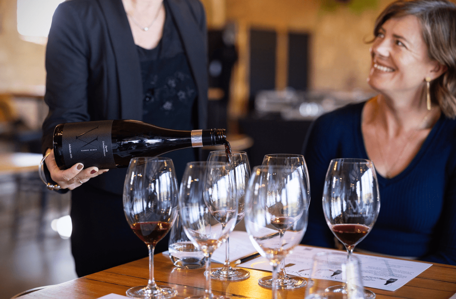 A lady enjoying a wine tasting at Varney Wines. A tasting of Syrah is being poured into a glass.