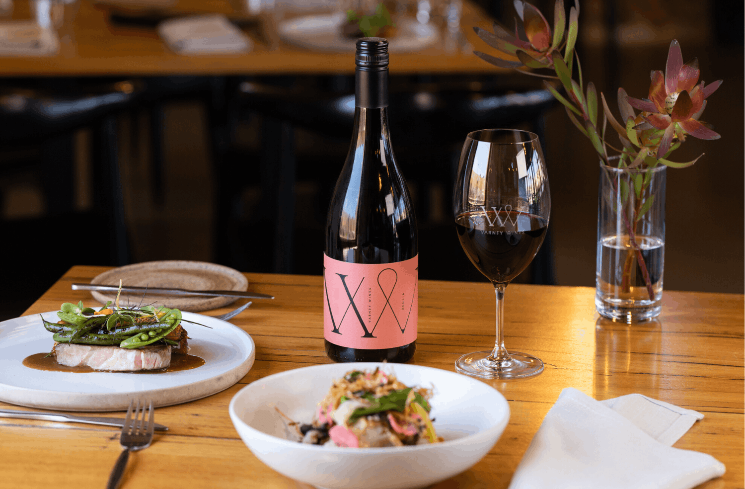 Varney WInes Mencia bottle on table with food at the Varney Wines cellar door and tasting room in Old Noarlunga.