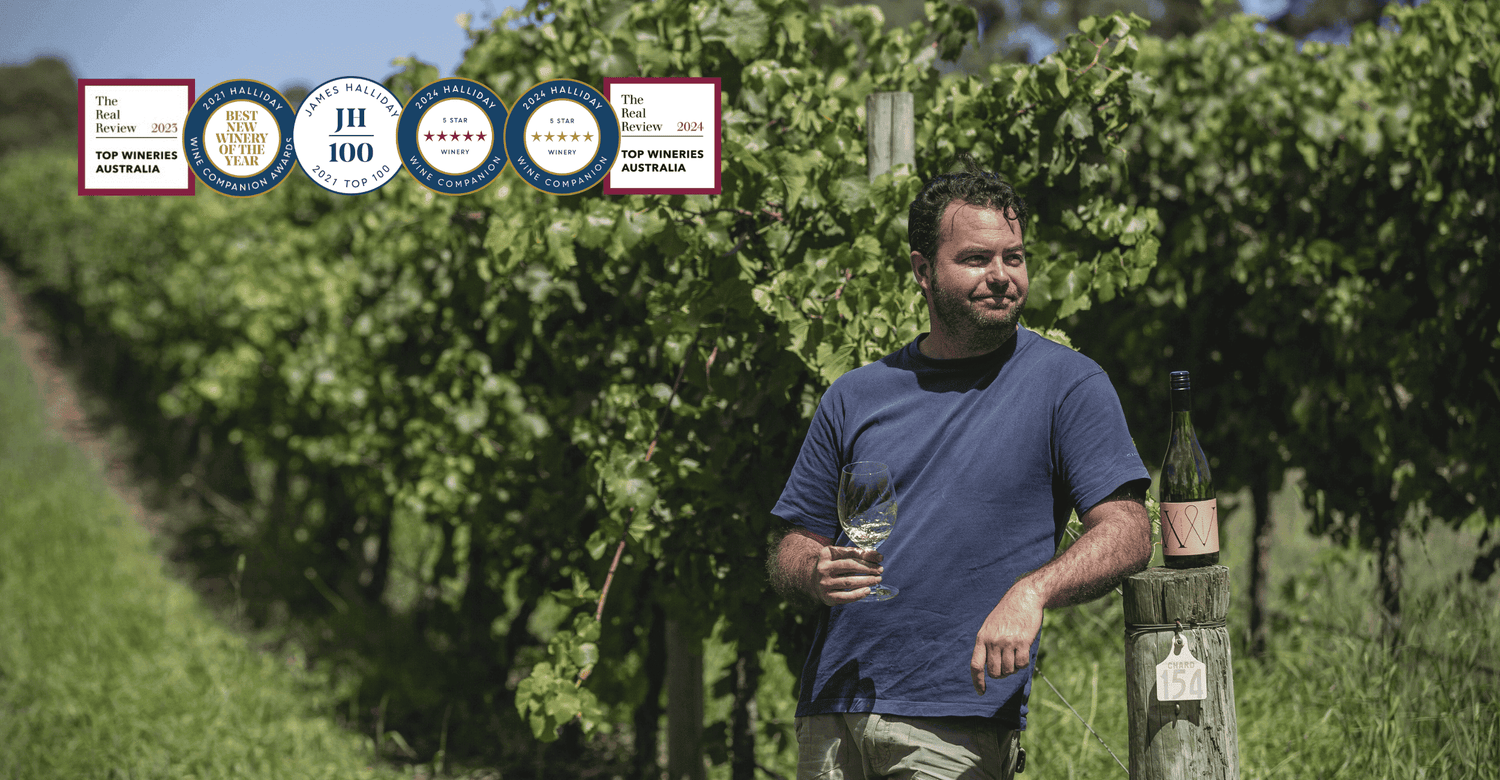 Winemaker, Alan Varney, holding a glass of Chardonnay and enjoying the Adelaide Hills vineyards. Recent awards in top left hand corner of image.